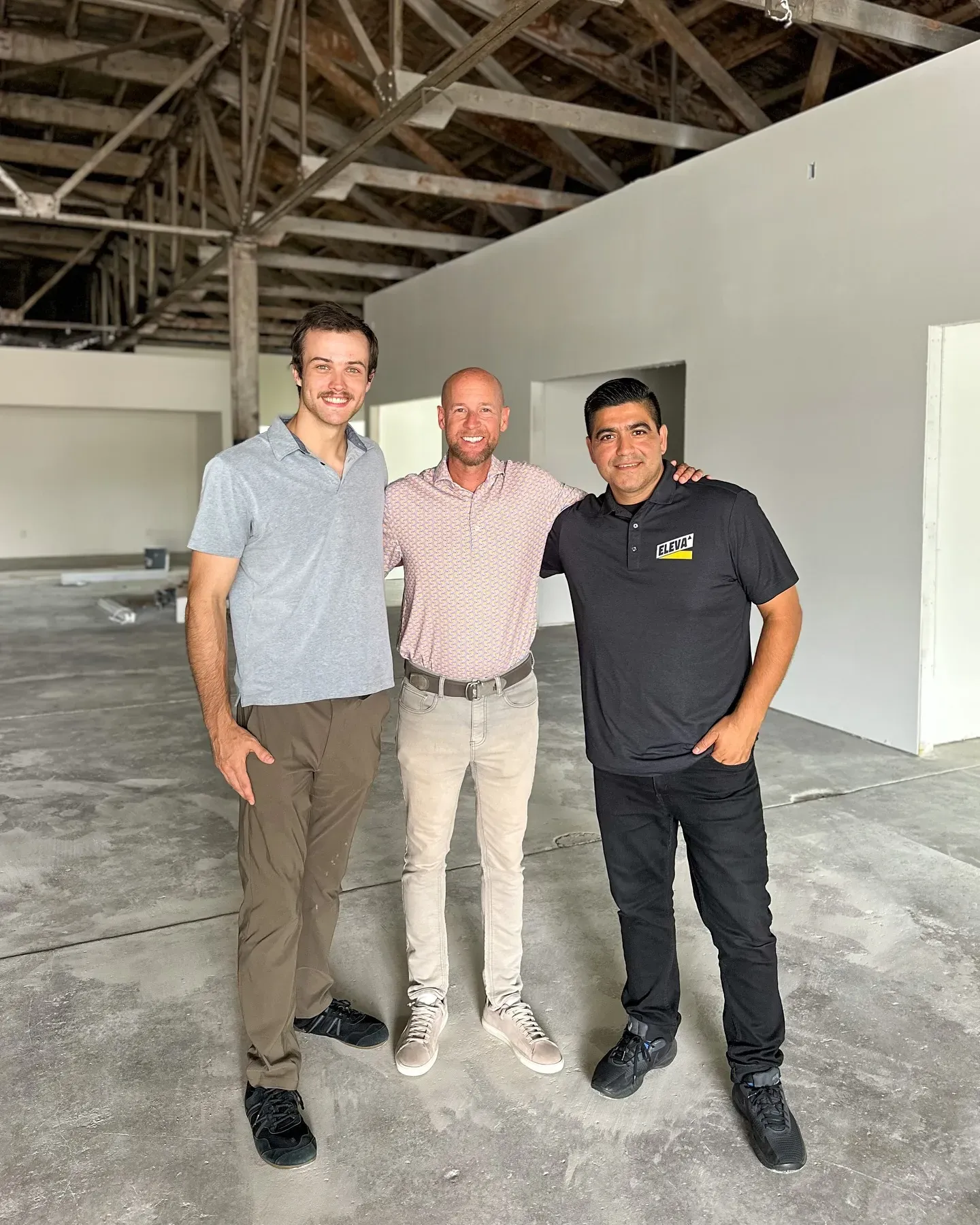 Tal, Chris, Obee posing for a picture inside of a pre-renovated Co-Create Hub